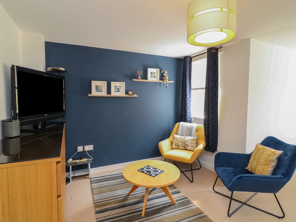 A living room with a television and a side table at No 39 Ashbourne