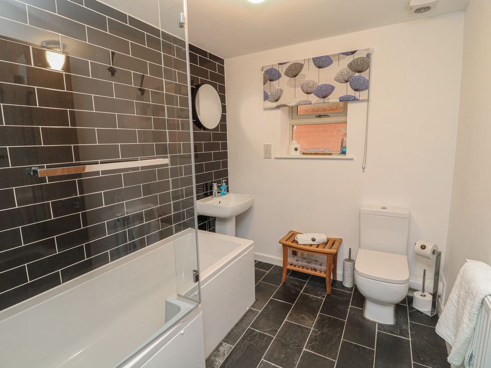 A bathroom with a bath, shower, toilet, and sink at No 39 Ashbourne