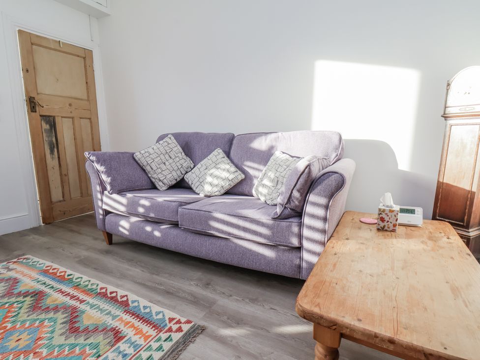 A living room with a purple sofa and wooden table at 1 Castle Terrace