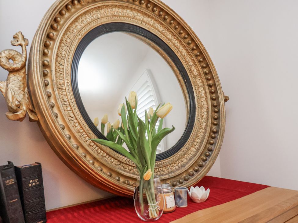 A mirror with tulips in a vase on a table at 1 Castle Terrace in Thirsk