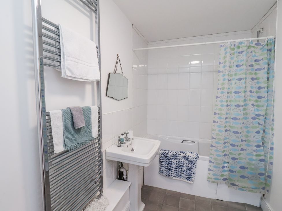 A bathroom with a sink and shower curtain at 1 Castle Terrace Thirsk
