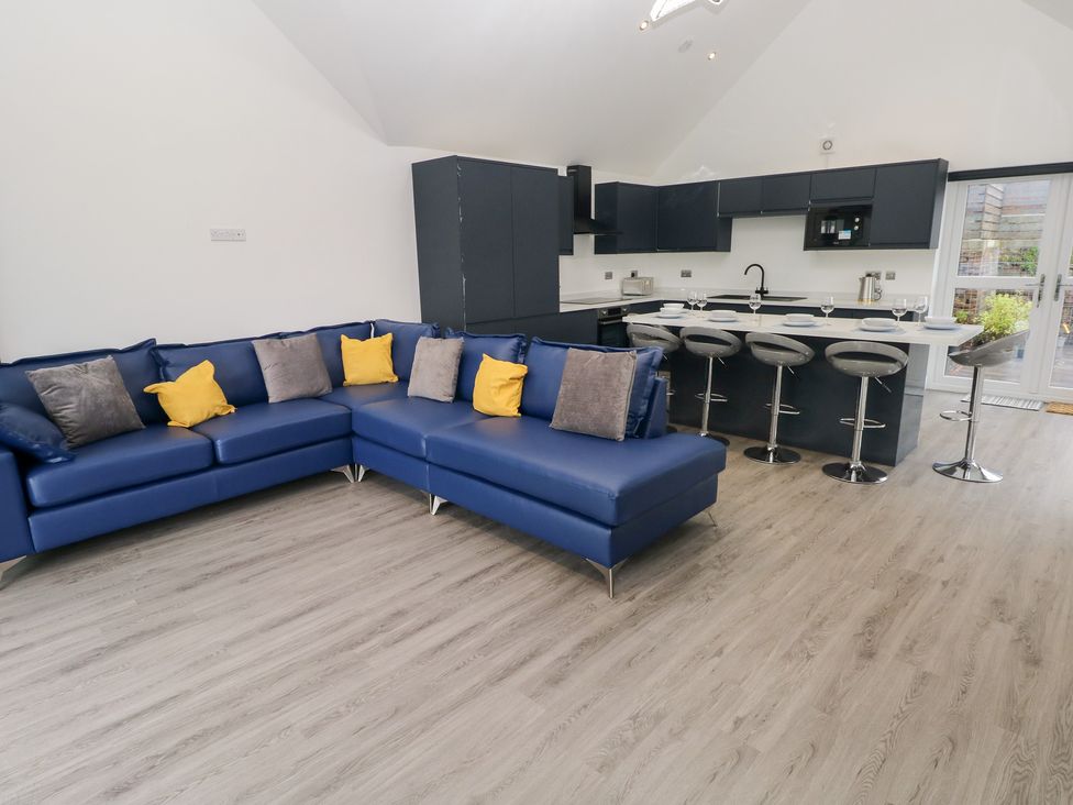 A living room with a sofa and kitchen area at Cottage 1 in Laugharne