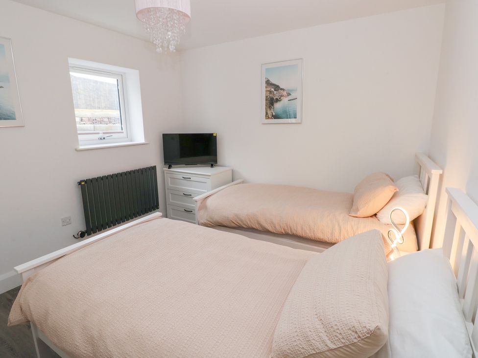 A bedroom with two beds and a television at Cottage 1 in Laugharne