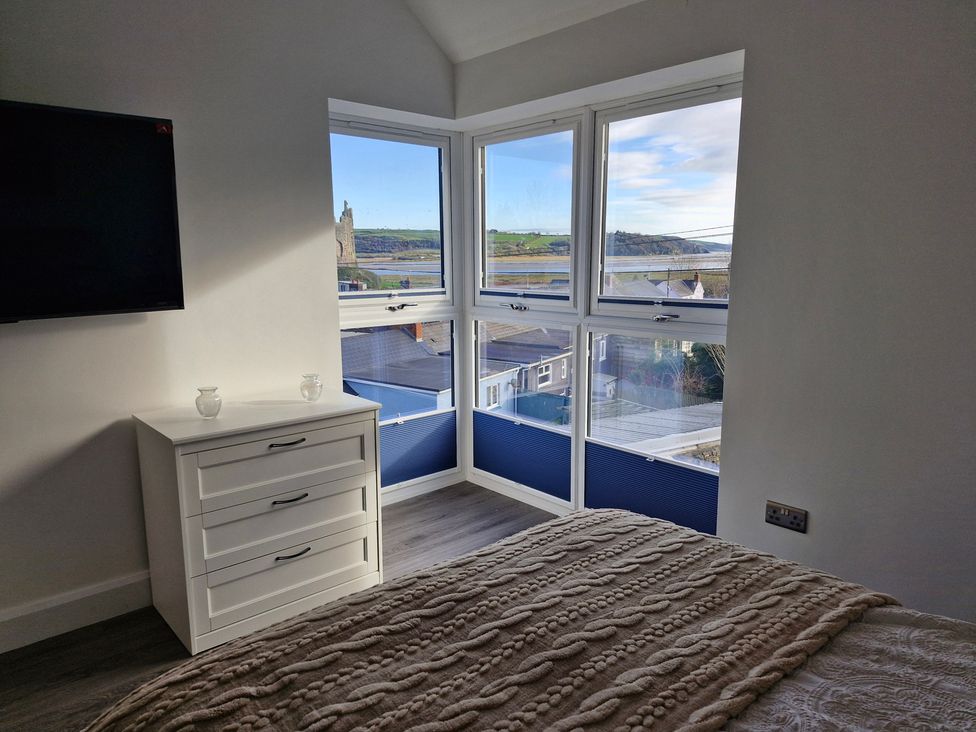 A bedroom with a television and chest of drawers at Milkwood Villa in Laugharne