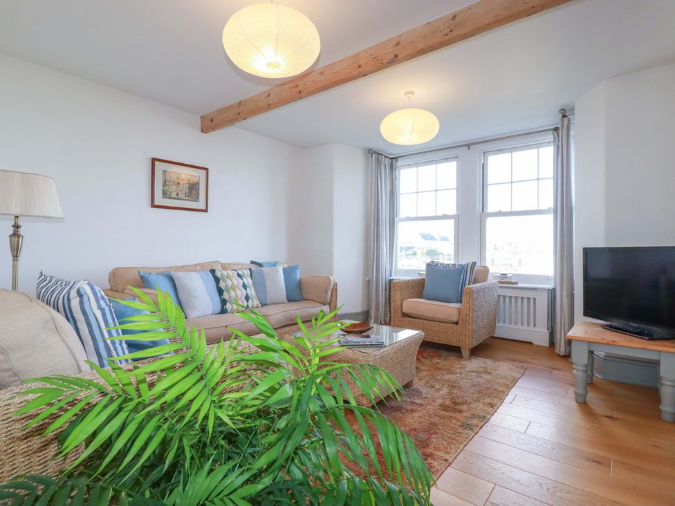 A living room with a sofa and armchair at Tradewinds in Newquay