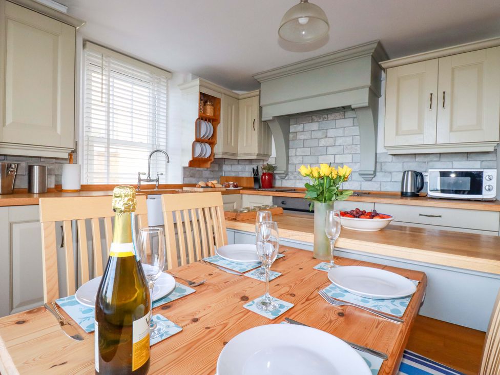 A kitchen with a dining table and chairs at Tradewinds in Newquay