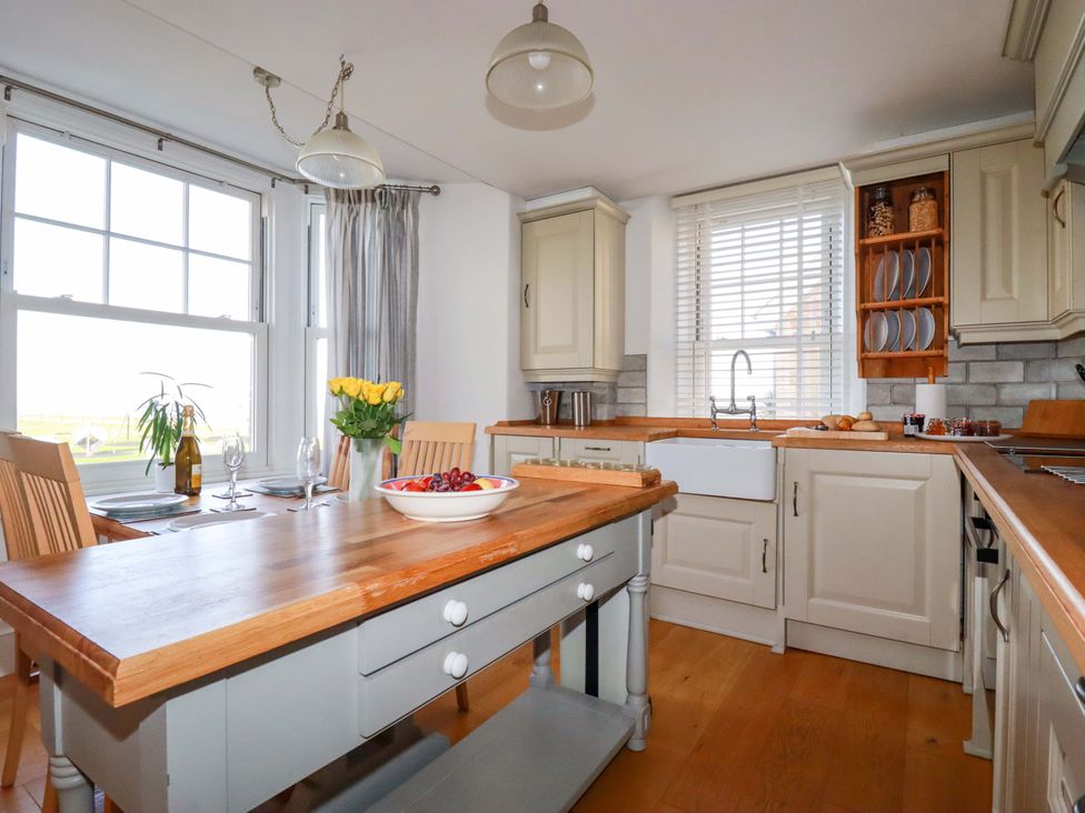 A kitchen with a table and chairs at Tradewinds in Newquay