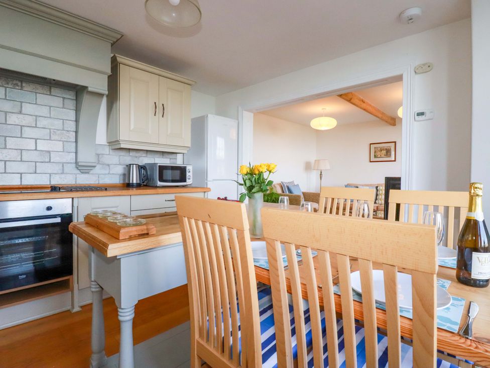 A kitchen with a dining table and chairs at Tradewinds in Newquay