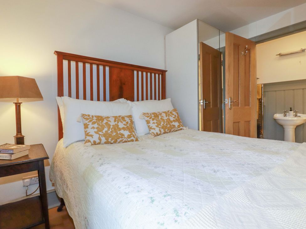 A bedroom with a bed and lamp at Tradewinds in Newquay