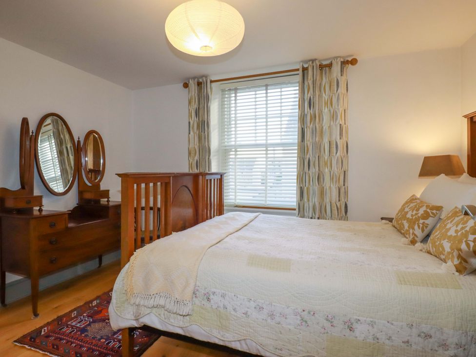 A bedroom with a bed and dressing table at Tradewinds in Newquay
