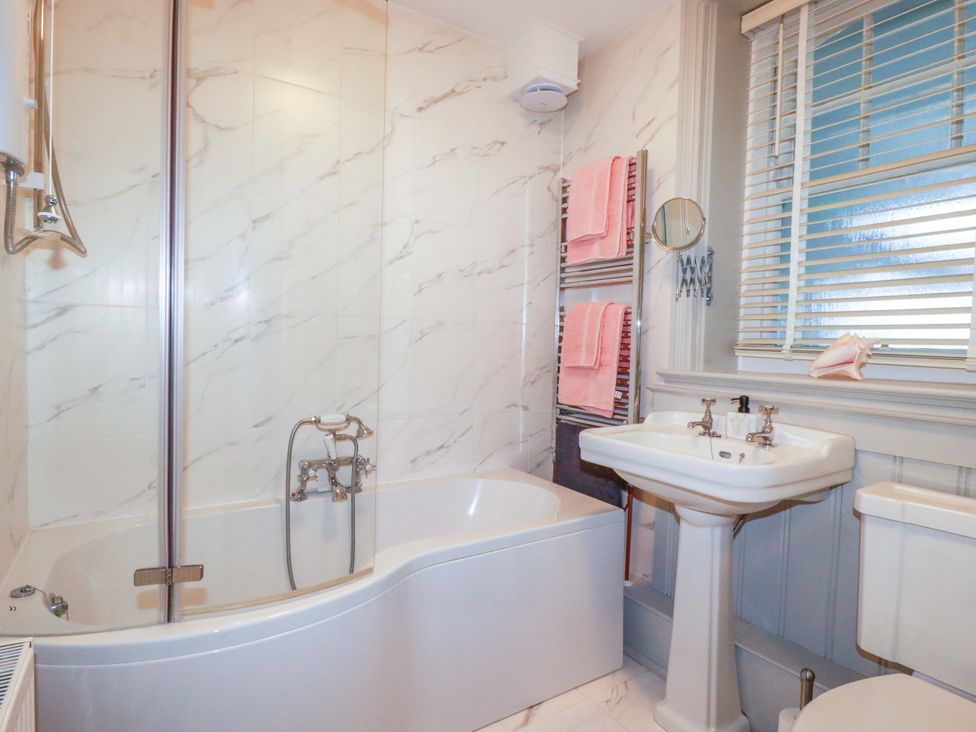 A bathroom with a bathtub, sink, and toilet at Tradewinds in Newquay