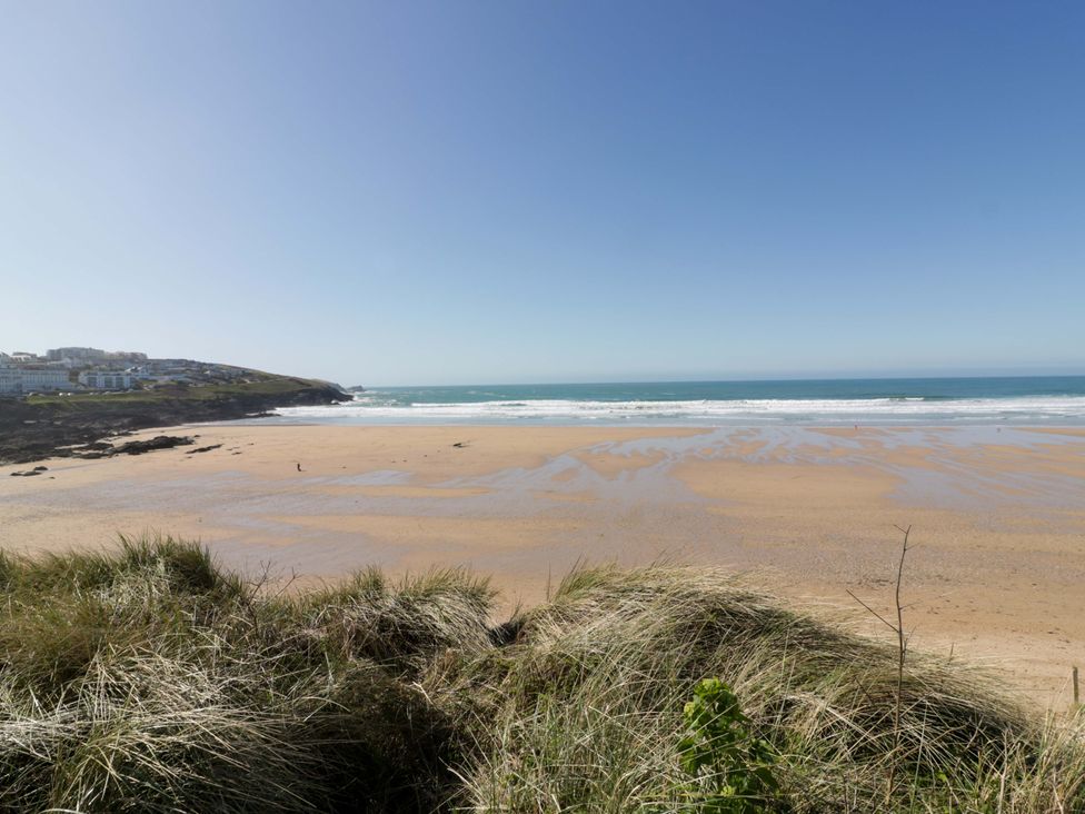 A beach view with sand and grass at Tradewinds in Newquay