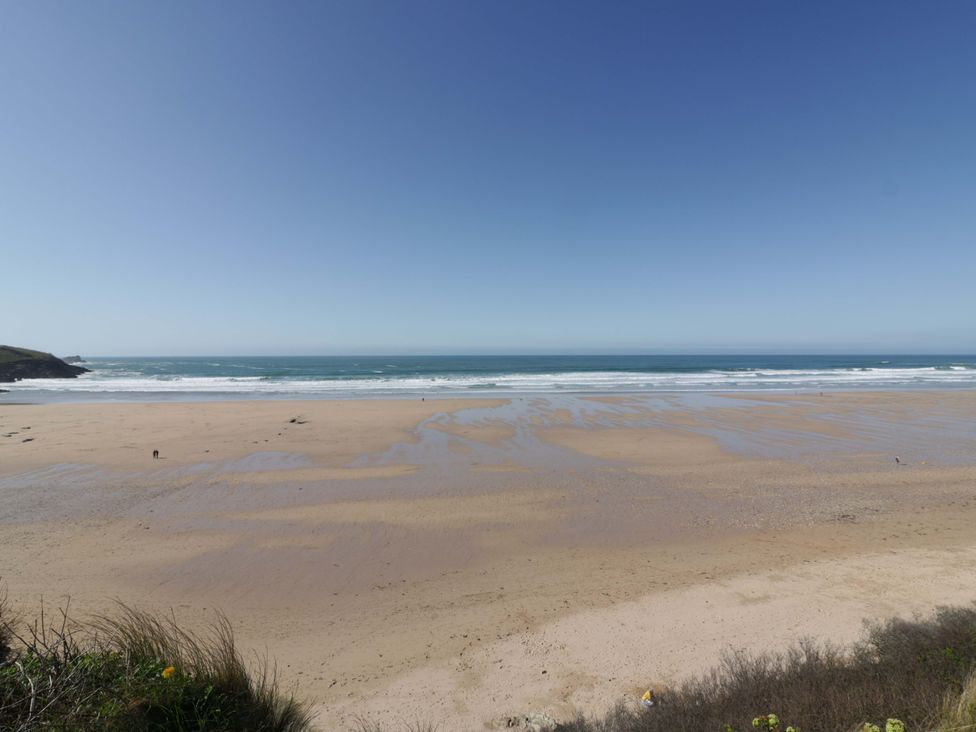 A beach with sand and ocean waves at Tradewinds in Newquay