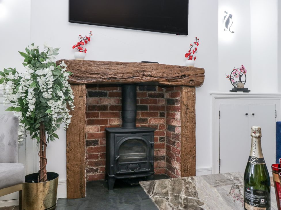 A fireplace with a stove and wooden mantel in a living room at Aspen Boutique