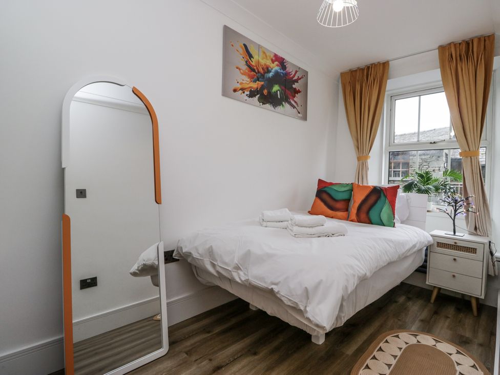 A bedroom with a bed, mirror and window at Aspen Boutique