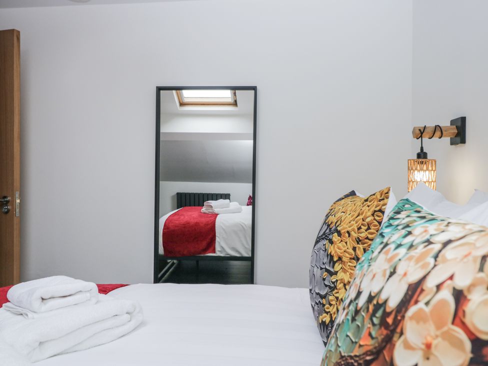 A bedroom featuring a bed with pillows and a mirror at Aspen Boutique