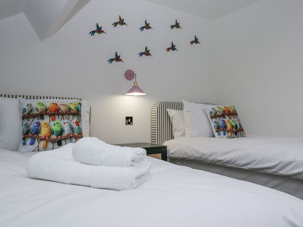 A bedroom with two beds and colorful pillows at Aspen Boutique
