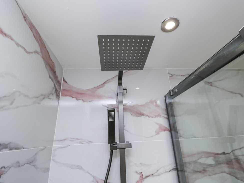 A shower with a rain showerhead and handheld shower at Aspen Boutique