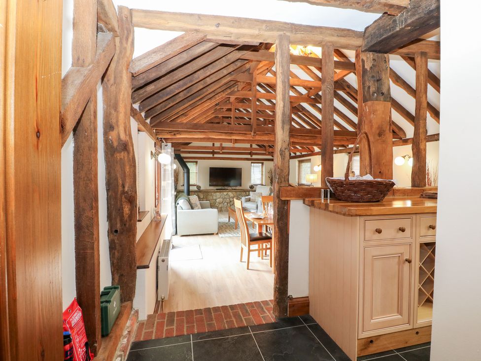 A living room with beams and a dining area at WEST LODGE Ashford