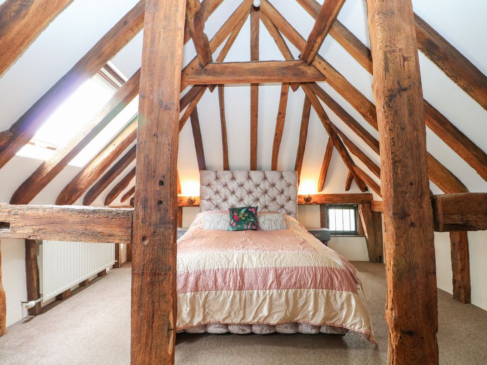 A bedroom with a bed and wooden beams at WEST LODGE in Ashford