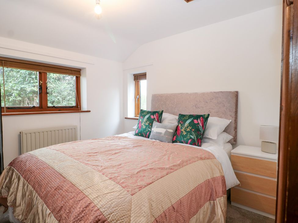 A bedroom with a bed and windows at WEST LODGE Ashford