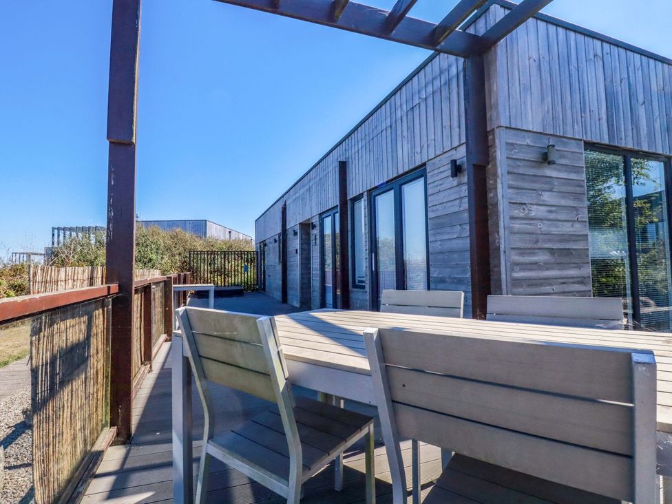 An outdoor seating area with a table and chairs at Gwel An Mor in Portreath
