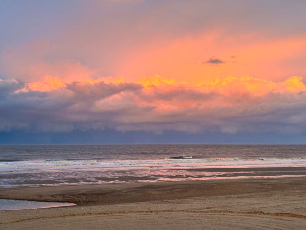 A scenic view of the ocean with clouds at sunset