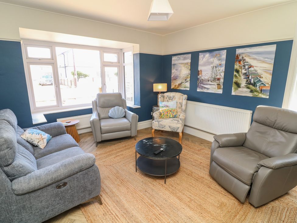 A living room with a couch and wall art at 54 George Street Mablethorpe