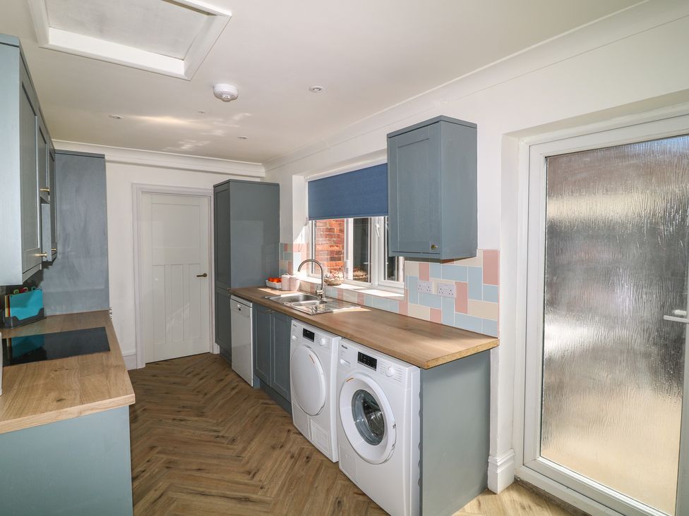 A kitchen with washing machine and sink at 54 George Street in Mablethorpe