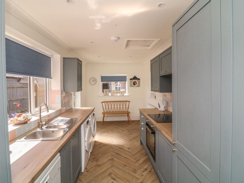 A kitchen with a sink and washing machine at 54 George Street in Mablethorpe