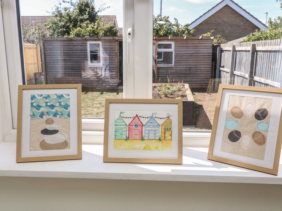 Three framed paintings on a windowsill overlooking a garden at 54 George Street Mablethorpe