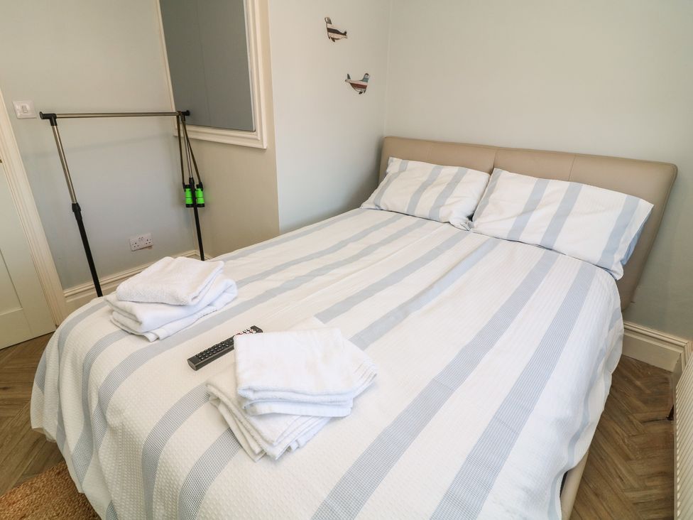 A bedroom with a double bed and towels on the bed at 54 George Street Mablethorpe