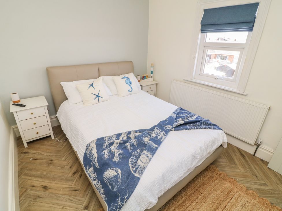 A bedroom with a bed and bedside table at 54 George Street Mablethorpe