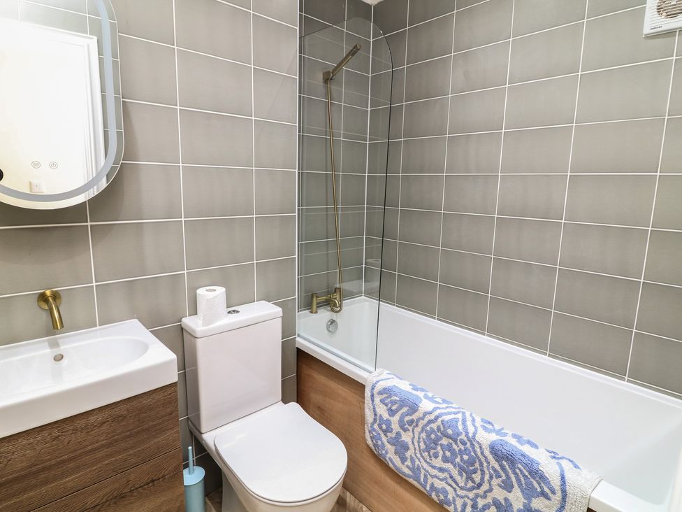 A bathroom with a sink, toilet, and bathtub at 54 George Street Mablethorpe