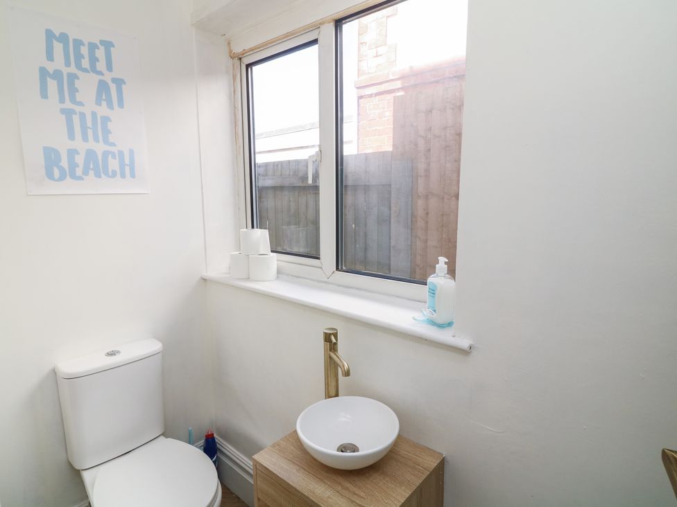 A bathroom with a toilet and sink at 54 George Street in Mablethorpe