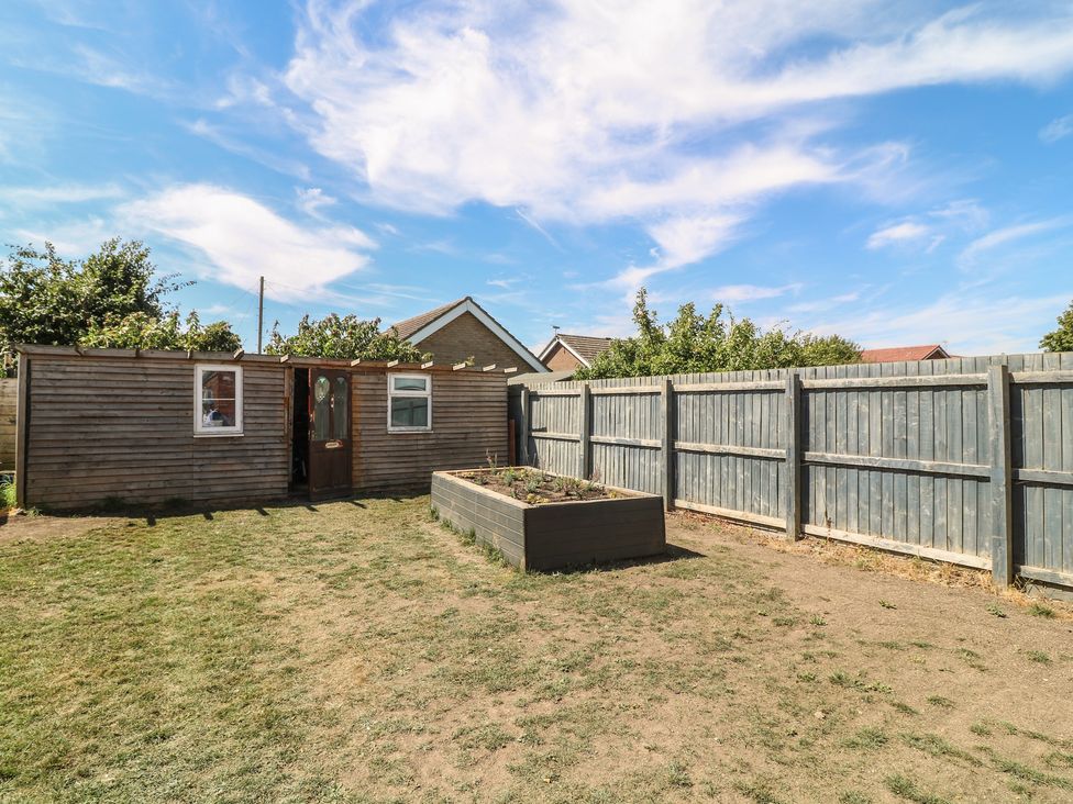 A garden with a shed a door and a fenced area at 54 George Street Mablethorpe