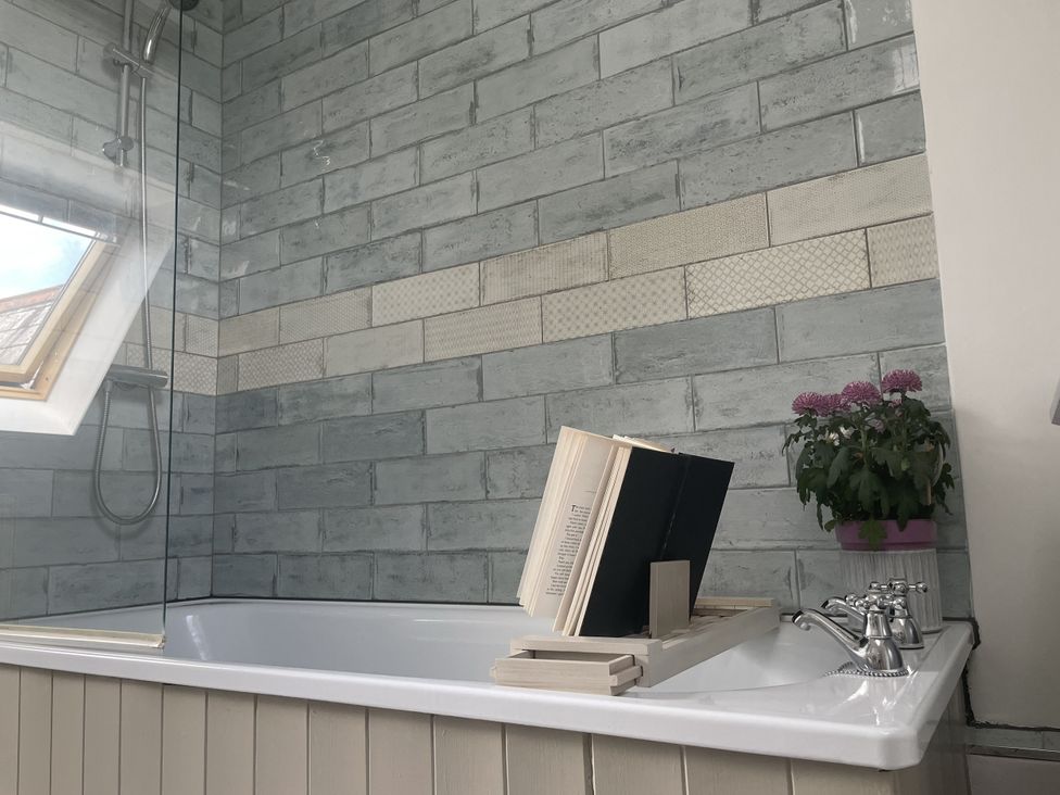 A bathroom with a bathtub and a shower at Butlers Loft in Par