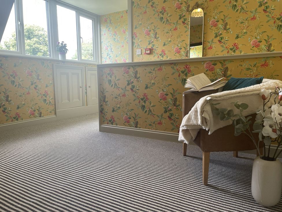 A sitting room with an armchair and a plant at Butlers Loft in Par