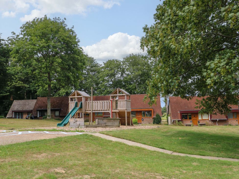 An outdoor area with a playground and buildings at Daisy Cottage in Pevensey