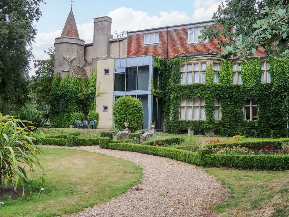 A garden with a pathway and seating area at Daisy Cottage Pevensey