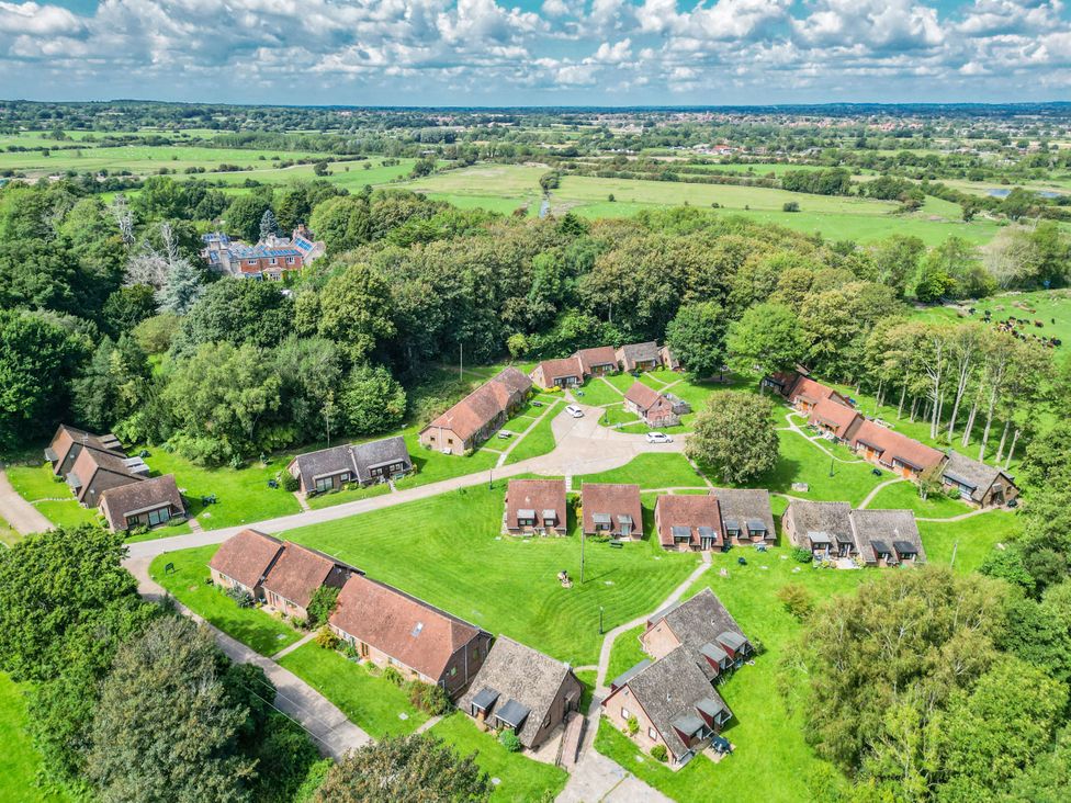 A group of cottages arranged in a circle surrounded by grass at Daisy Cottage in Stone Cross