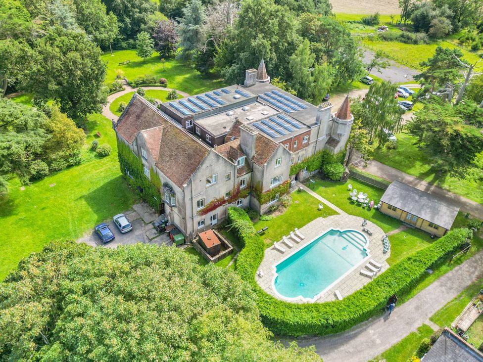 An aerial view of a building with a swimming pool and garden at Daisy Cottage Stone Cross