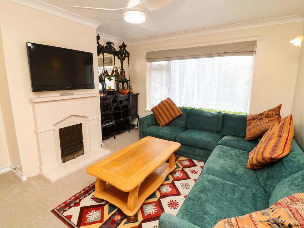 A living room with a green sofa and a coffee table at 5 Overstone Drive in Wisbech