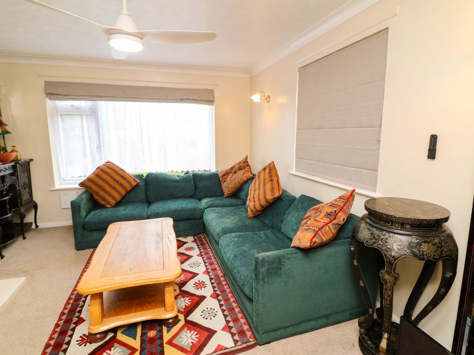 A living room with a green sofa and a coffee table at 5 Overstone Drive in Wisbech