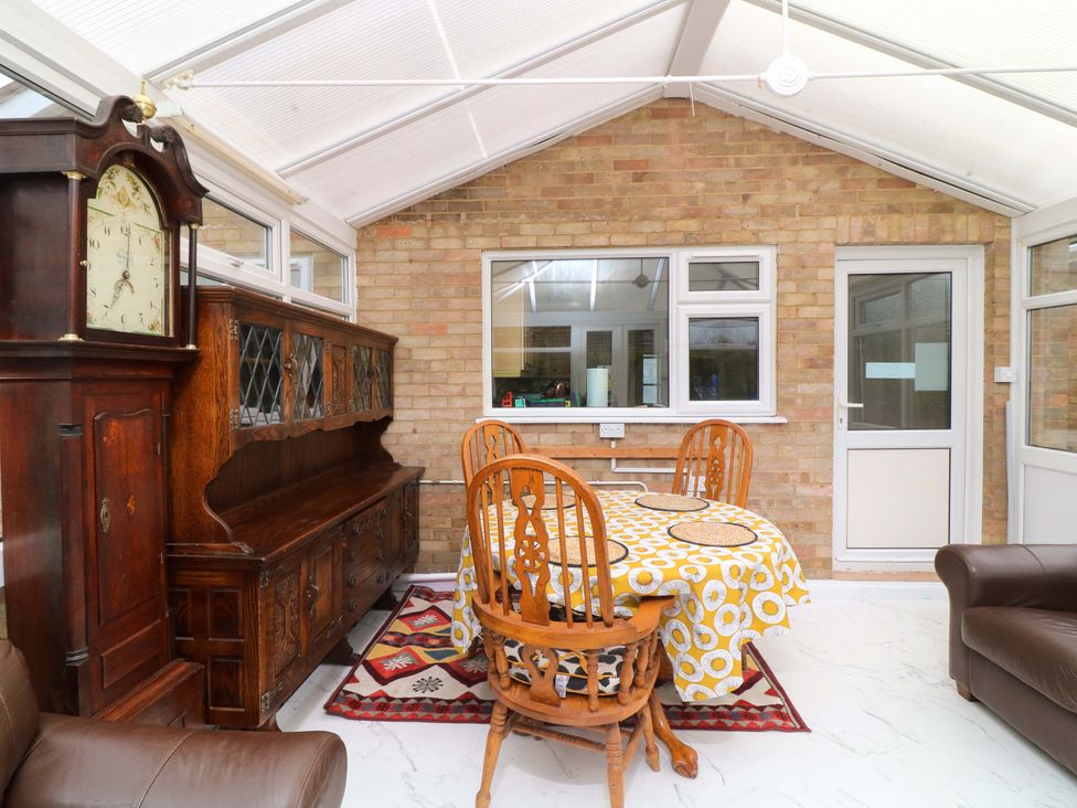 A conservatory with a dining table and chairs at 5 Overstone Drive, Wisbech