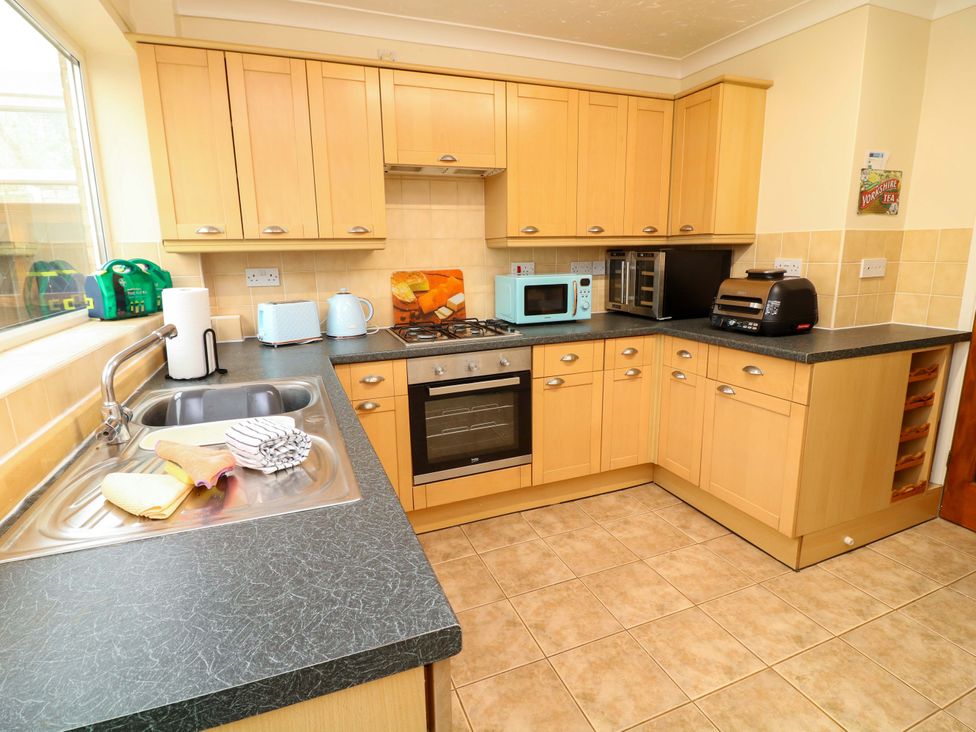 A kitchen with cabinets, sink, and appliances at 5 Overstone Drive in Wisbech