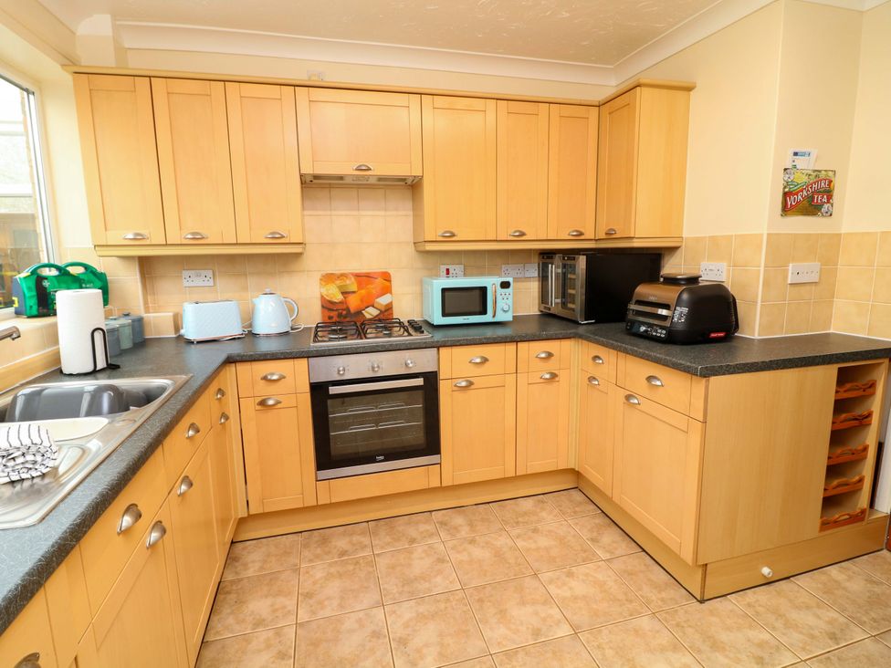 A kitchen with appliances and cabinets at 5 Overstone Drive Wisbech