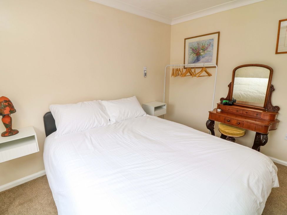 A bedroom with a bed and dressing table at 5 Overstone Drive in Wisbech