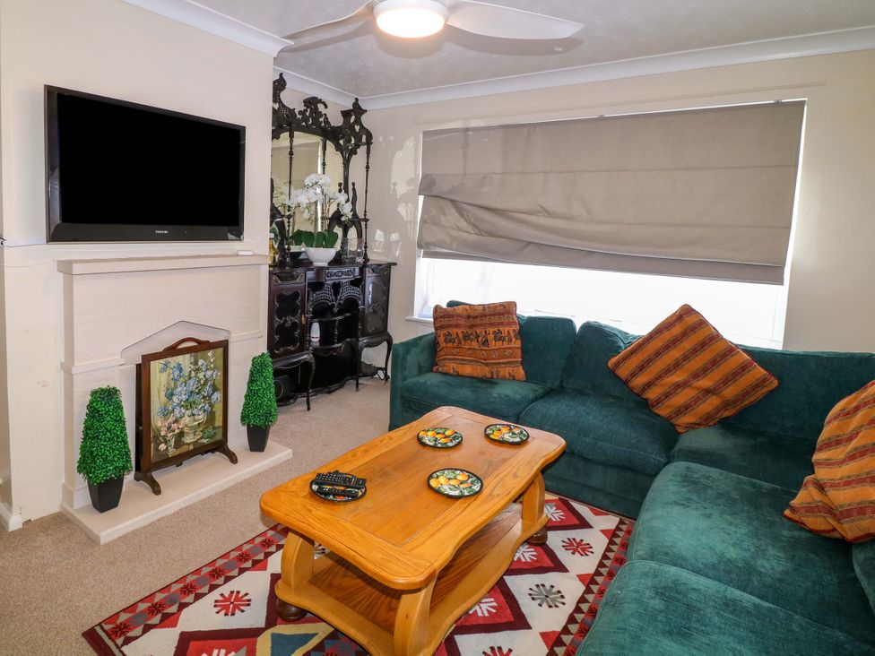 A living room with a sofa, coffee table, and television at 5 Overstone Drive in Wisbech