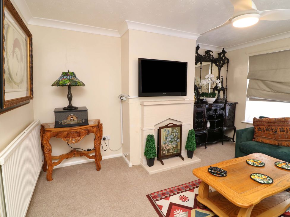 A living room with a television and a lamp at 5 Overstone Drive in Wisbech